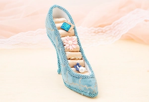 Detailed embroidery on light blue velvet high heel ring holder with gold woven trim