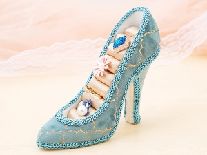 Detail of peacock blue velvet high heel ring holder with gold embroidery and satin slots