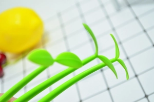 Close-up of vibrant green sprout-shaped creative pens on a white mesh background