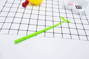Close-up of green sprout-shaped gel pen with silicone leaves on a grid background