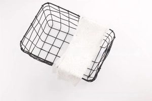 Close-up of black metal wire storage basket with elegant white lace decorative liner