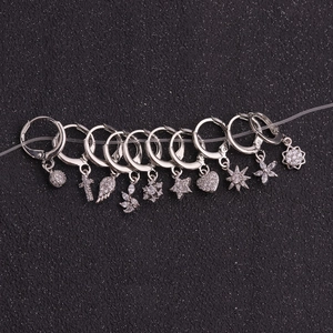 Set of silver hoop earrings with diverse zircon pendants like sun, cross, and heart
