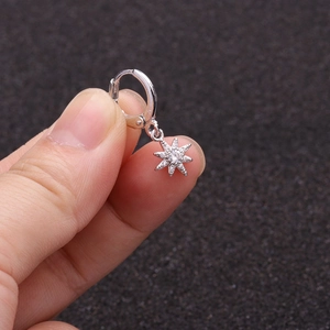 Detailed view of a silver hoop earring featuring a sparkling zircon star-shaped pendant