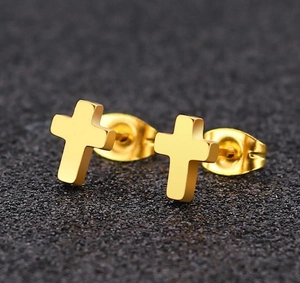 Macro view of minimalist golden stainless steel cross earrings with polished finish