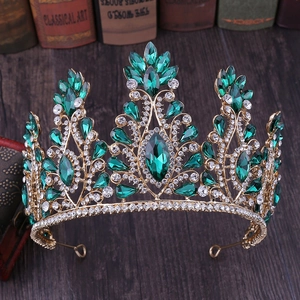 Close-up of golden bridal tiara with emerald green gems and clear rhinestones