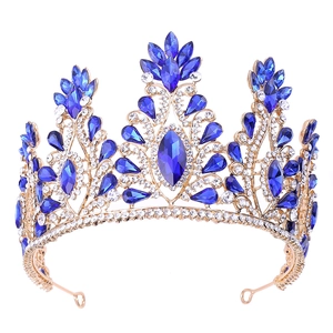Detailed view of golden princess crown with blue teardrop crystals and clear rhinestones
