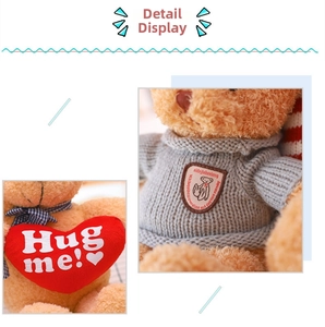 Primer plano de un oso de peluche marrón con corazón rojo Hug Me y jersey de punto gris