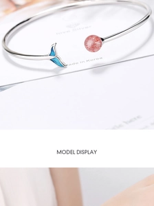 Detailed close-up of a silver fish tail bracelet with pink strawberry quartz and blue accent