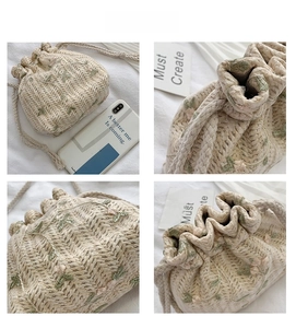 Detail view of woven bucket bag with floral embroidery and drawstring closure