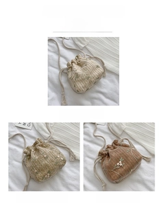 Detail of woven straw bucket bag with floral embroidery and drawstring closure in three colors