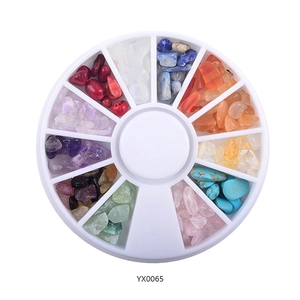 Detailed view of 12-color irregular nail art stones in a white rotating carousel wheel