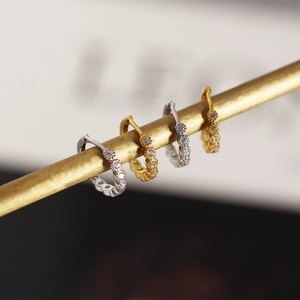 Close-up of gold and silver S925 sterling silver hoop earrings with pavé cubic zirconia