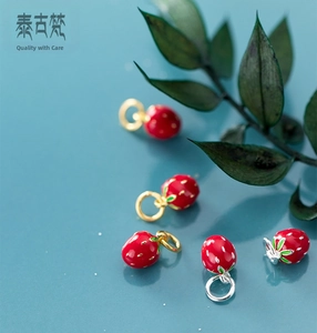 Detail of strawberry-shaped S925 silver enamel charms with red coating and green leaves