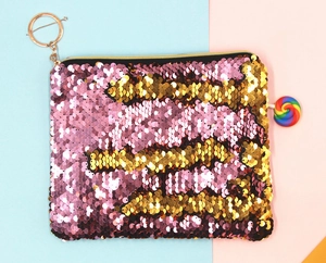 Detailopname van de omkeerbare roze en gouden lovertjes op deze stijlvolle make-uptas.