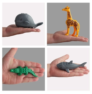 Detailed view of hand-held small building blocks featuring whale, giraffe, and crocodile