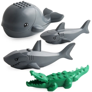 Collection of toy animal blocks including a grey whale, sharks, and a green crocodile