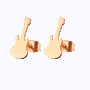 Detailed view of rose gold guitar shaped stud earrings with a polished metallic finish