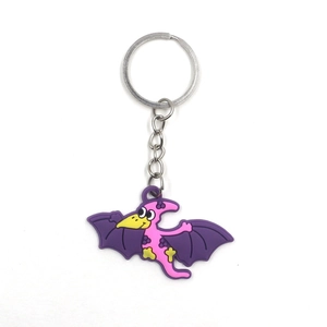 Detailed view of pink PVC pterodactyl dinosaur keychain with purple polka dot wings
