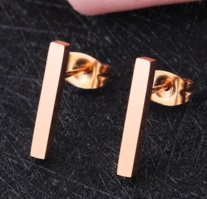 Detail of rose gold bar stud earrings with polished mirror finish and butterfly backings
