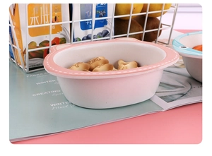 Pink cat-ear shaped bamboo fiber bowl for kids shown with small cookies inside