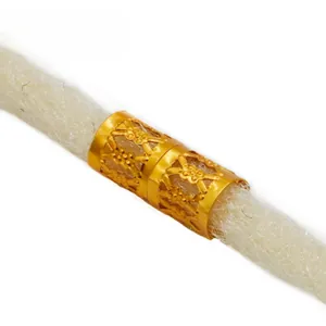 Macro detail of golden hollow floral engraved metal rings for dreadlocks hair braiding