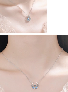 Close-up of crescent moon necklace with blue water-drop gemstone and star diamond