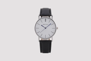 Detail shot of a silver watch featuring a white dial, blue hands, and black leather strap