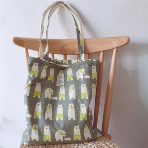 Close-up of cotton tote bag with polar bear patterns on a light wooden chair