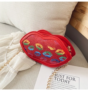 Detail of red lip-shaped crossbody bag with rainbow sequin lip prints and gold chain strap