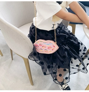 Pink lip-shaped glitter crossbody bag for kids with gold chain and colorful prints