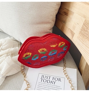 Macro detail of red glitter lip-shaped children bag with colorful prints and gold chain