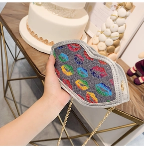 Detail of silver glitter lip-shaped crossbody bag with colorful prints and chain strap