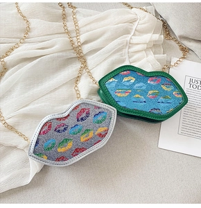Detail of colorful lip-shaped crossbody bags with sequins and golden chain straps