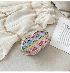 Detailed macro view of children lip-shaped crossbody bag with pink glitter and gold chain