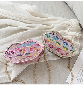 Detail of pink and gold lip-shaped crossbody bags with colorful sequins and metal chain