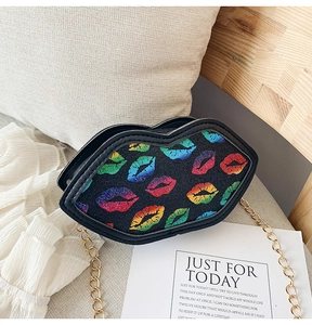 Detail of a black lip-shaped mini chain bag with colorful glitter lipstick prints