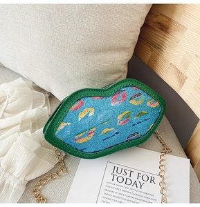 Detail of blue lip-shaped kids crossbody bag with glitter patterns and gold chain strap