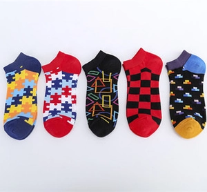 Detailed flat lay of five pairs of colorful cotton boat socks with food themed patterns