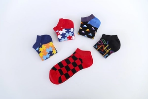 Detailed view of assorted colorful patterned cotton ankle socks for men in various geometric designs