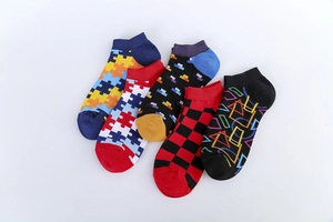 Flat lay of five pairs of men's colorful patterned ankle socks with geometric designs