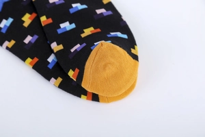 Close-up of cotton blend socks featuring colorful geometric patterns and yellow toe detail