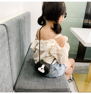 Rear view of a young girl wearing a cute black bear-shaped mini crossbody bag