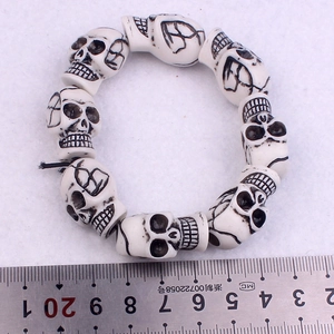 Punk skull bead bracelet with elastic cord measured against a metal ruler for scale