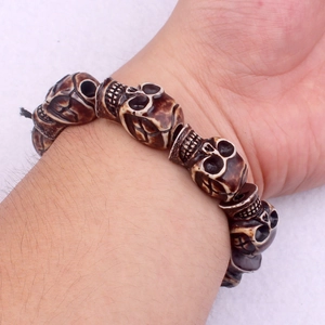 Detailed close-up of a punk skull bead bracelet with antique bone finish on wrist