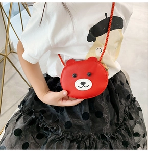 Detailed view of red mini bear crossbody bag worn by a girl in white t-shirt