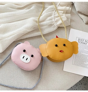 Close-up of cute cartoon pig and chick crossbody bags with woven shoulder straps