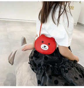 Rear view of a young girl wearing a red bear-shaped mini crossbody bag for kids
