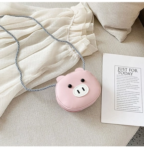 Detailed shot of pink cartoon pig child crossbody bag with blue braided rope strap