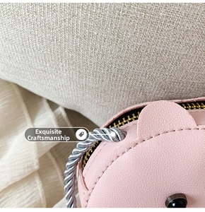 Detailed macro view of pink litchi leather texture and golden zipper on kids animal purse