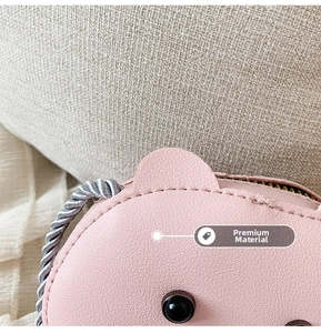 Close-up of pink animal-shaped mini bag with litchi grain faux leather and woven handle